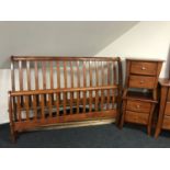 A contemporary stained 5' rail bed and a pair of two drawer bedside chests