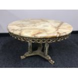 A good quality variegated onyx coffee table, on brass tri-form base, with onyx pillars, width 75 cm.