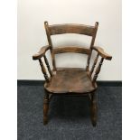 An antique pine kitchen armchair