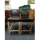 A pair of brown leather bar stools