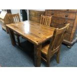 A plantation pine table and three rail back chairs