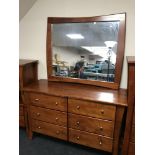 A contemporary stained pine six drawer chest with over mantel mirror