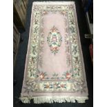 A pink fringed Chinese rug