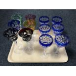 A tray of two sets of six coloured crystal wine glasses