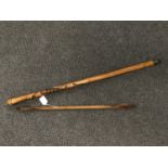 An African walking cane together with a pair of wooden shaft arrows bearing the name Honorable Ble