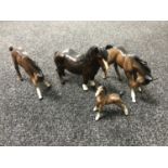 Three brown gloss Beswick standing foals and a Royal Doulton foal