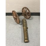 A heavy brass cannon with wooden wheels,