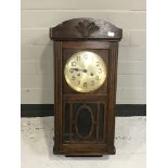 An oak cased wall clock with silvered dial