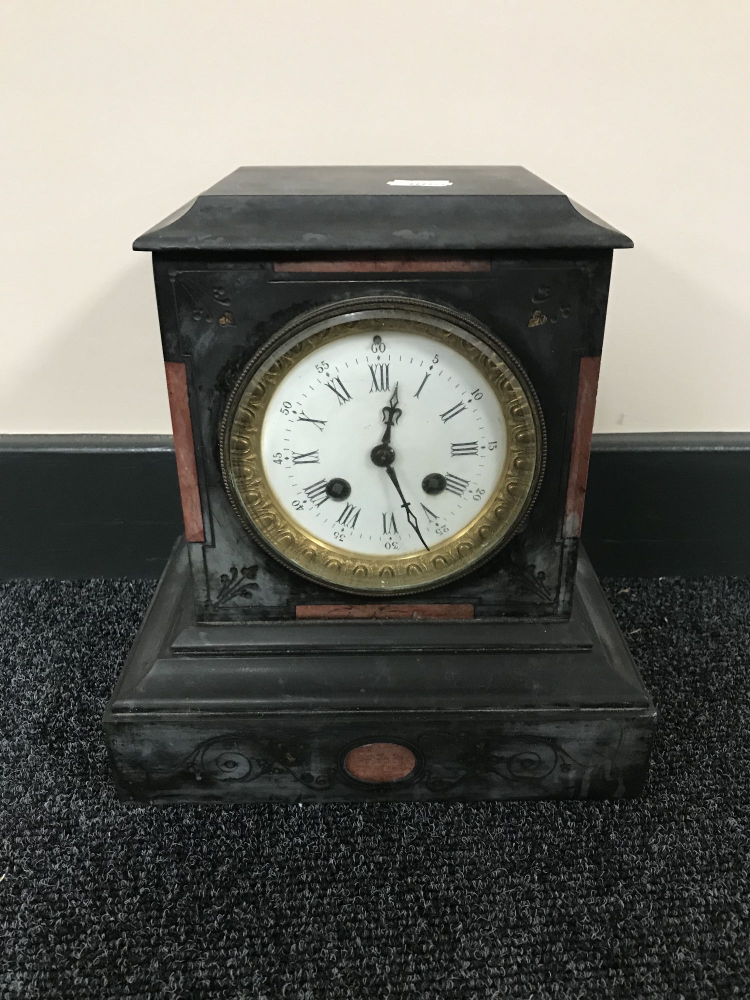 A Victorian slate mantel clock with enamel dial