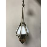 A contemporary brass light fitting in the form of a vintage oil lamp with glass shade and chimney