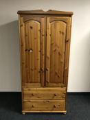 A pine double door wardrobe fitted with two drawers