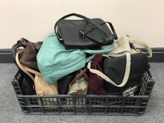 A basket containing a large quantity of ladies handbags together with a fur wrap