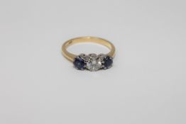 An 18ct gold three stone sapphire and diamond ring, the central stone weighing approximately 0.
