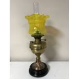 An early twentieth century brass National Lamp oil lamp with yellow glass shade and chimney