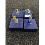 Four boxed Swarovski Crystal figures; giraffe, flower in pot,