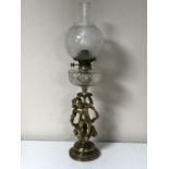 An antique oil lamp with glass chimney and shade on a cherub base CONDITION REPORT: