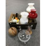 A box containing converted brass oil lamps with chimneys and shades,