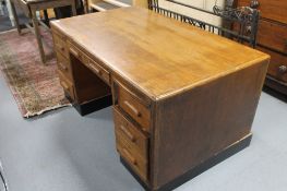 A mid twentieth century oak desk fitted with seven drawers
