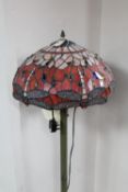 A Tiffany style standard lamp with leaded glass shade of dragon fly design