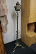 An antique brass rise and fall standard oil lamp