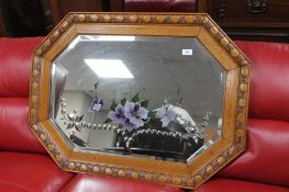 An early twentieth century carved oak framed bevelled mirror with hand painted flowers