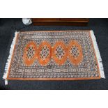 A Persian rug of geometric design on peach ground 78 cm x 120 cm