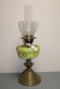 An antique brass oil lamp with a green glass shade CONDITION REPORT: Wear to gilding