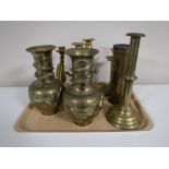 A tray containing five brass candlesticks,