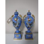 A pair of Noritake twin handled gilded vases with lids on stands,