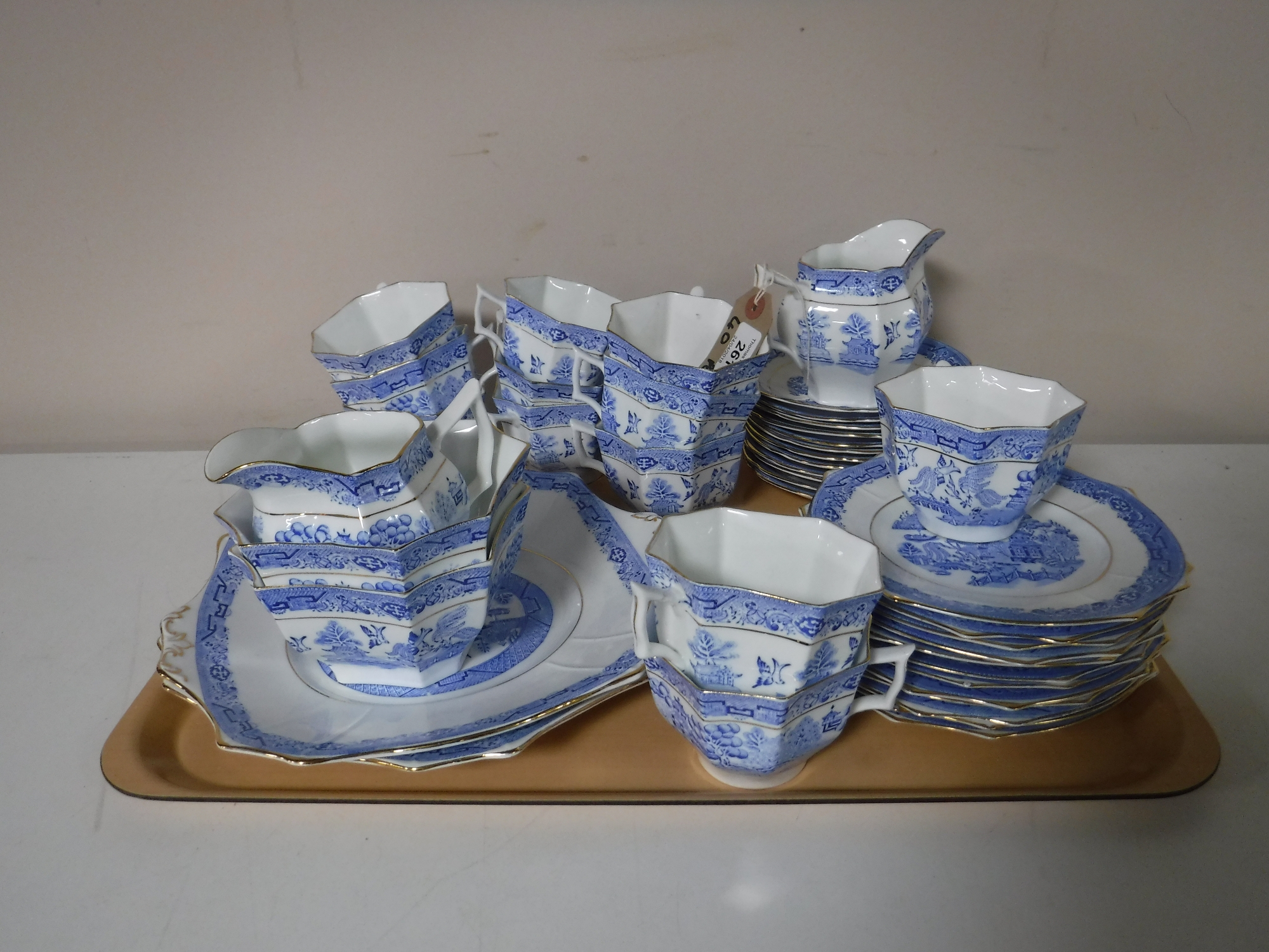 Forty two pieces of blue and white gilt-rimmed Willow pattern hexagonal-shaped tea china (two