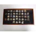 A display case of thirty eight enamelled badges related to shipping