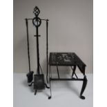 A large metal trivet and a four piece companion set on stand
