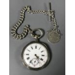 A silver pocket watch with silver Albert and medal.