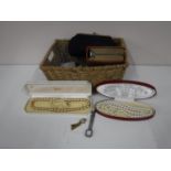 A wicker basket containing costume jewellery, simulated pearls, gents shaving set, compact,