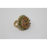 A high carat gold multi-gemstone ring, set with tiers of turquoise, emeralds, rubies,