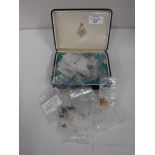 A box of various loose gemstones including amethysts, garnets, citrines,