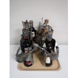 A tray containing six contemporary wine bottle holders, together with three bottles of red wine,