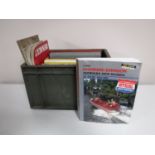 A crate containing vintage vehicle manuals, including Riley 2.