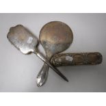 A silver backed hand mirror and two brushes