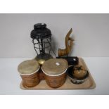 A tray containing a paraffin lamp, hand drums, wooden maracas,