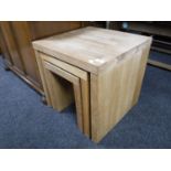 A nest of three contemporary oak tables