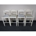 A set of four white bar stools