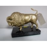 A gilt metal figure of a bison on a marble base