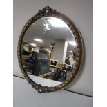 An early twentieth century ornate oval gilt framed mirror