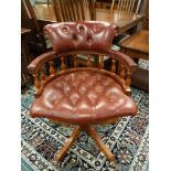A chesterfield style buttoned burgundy leather captain's chair,