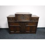 An early 20th century carved oak cocktail sideboard
