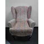 A wing back armchair upholstered in a pink floral fabric
