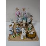 A tray containing continental figurines, including cherub with cello, cherub candlestick holder,