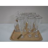 A tray containing a set of twelve gilt rimmed champagne flutes,