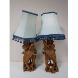 A pair of carved hardwood table lamps with shades
